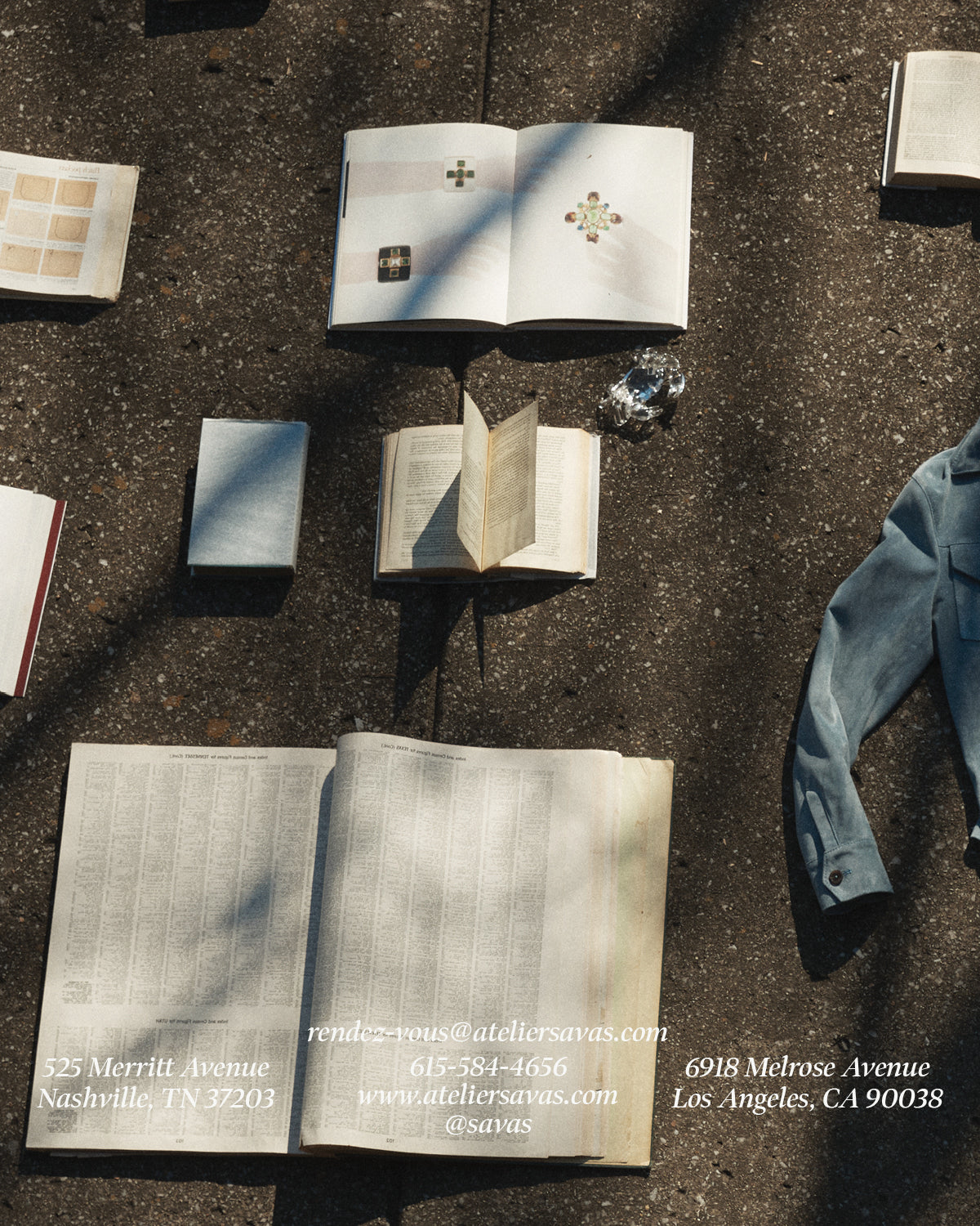 concrete sidewalk with books and Savas leather jacket lying on it.